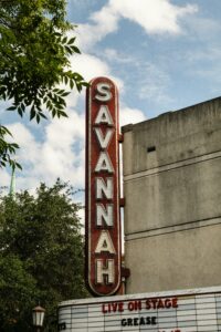 Vertical shot of the classic Savannah Theater sign in Georgia under a cloudy sky.