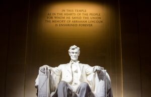 Illuminated Lincoln Memorial statue with engraved quote, Washington D.C.